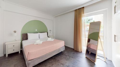 Un dormitorio con una cama grande y un espejo. en OneZeroTwo by Zoia Living, en Atenas