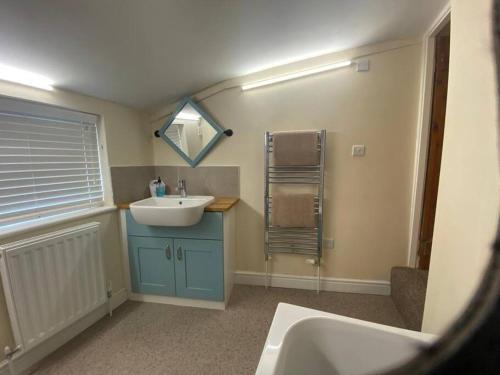 a bathroom with a sink and a mirror at Skippings in Beccles