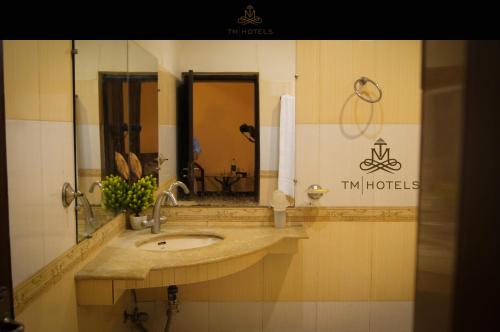 W łazience znajduje się umywalka i lustro. w obiekcie Shelton Accommodator w mieście Peszawar