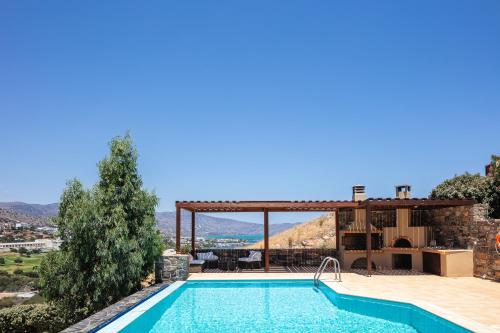 een villa met een zwembad en een huis bij Maris Villas in Elounda