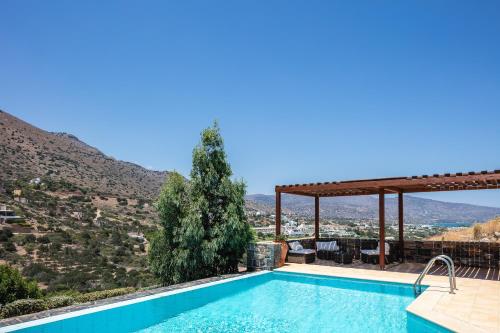 a swimming pool with a view of a mountain at Maris Villas in Elounda