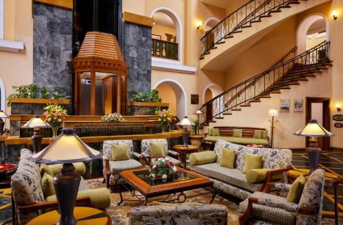 eine Lobby mit Sofas, Tischen und einer Treppe in der Unterkunft Fortune Resort Sullivan Court, Ooty - Member ITC's Hotel Group in Udagamandalam