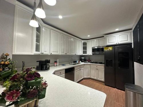 a kitchen with white cabinets and a black refrigerator at Residencia preciosa de 2 planta in San Salvador