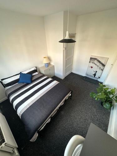 a bedroom with a black and white bed and a desk at Shoreditch Rooms R3 in London