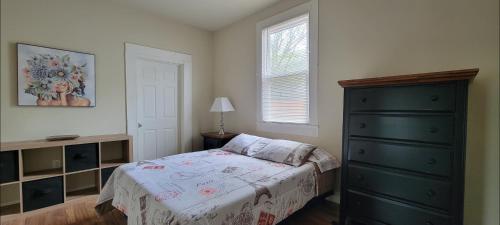 a bedroom with a bed and a dresser and a window at NOLA Hideaway RS in New Orleans