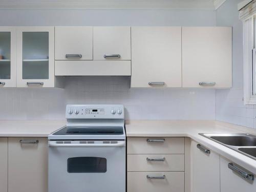 a white kitchen with a stove and a sink at Zenbreak Vuemont 245 in Saint Peter