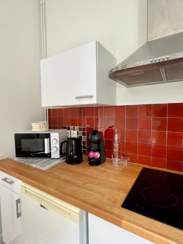 a kitchen with a wooden counter top with a microwave at Appartement Vichy - Hyper Centre in Vichy