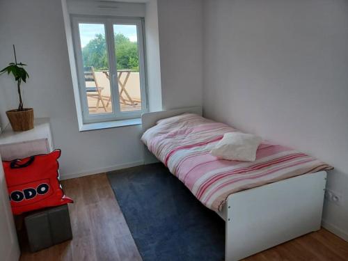 małe łóżko w pokoju z oknem w obiekcie Maison de ville - terrasse sud, a 10 min des plages w mieście Saint-Brieuc