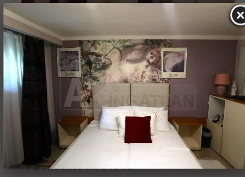 um quarto com uma cama branca e uma almofada vermelha em D6 apartment em Szeged