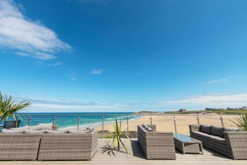 a group of chairs on a beach with the ocean at Fistral Beach Hotel and Spa - Adults Only in Newquay