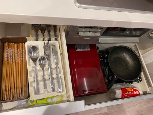 a drawer filled with utensils and a utensil at Hotel Jungle fun fun in Osaka