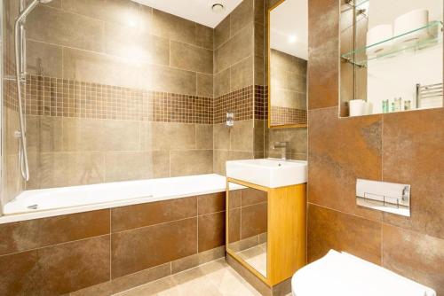 a bathroom with a sink and a tub and a toilet at Superb 2 bed 2 baths Apartment in Woolwich