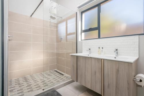 een badkamer met een wastafel en een douche bij Dorpshuis in Dullstroom