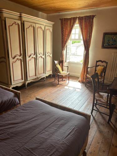 1 dormitorio con cama y ventana grande en Maison Garesché, en Nieulle-sur-Seudre