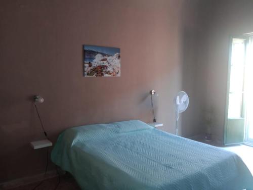 - une chambre avec un lit doté d'un couvre-lit bleu dans l'établissement Vicino l'Etna, à Tremestieri Etneo