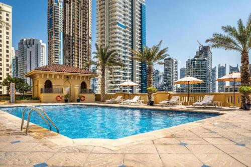 a swimming pool in a city with tall buildings at Neyar Beach Vibes in Dubai