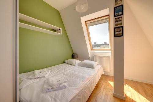 a bedroom with a white bed and a window at Surf&Sail Apartament Gdynia Orłowo, 400m Plaża, free parking in Gdynia