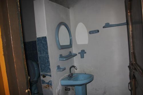 a bathroom with a blue sink and a mirror at Rakaposhi Amin Hotel & Restaurant Pissan Hunza Nagar Gilgit Baltistan in Gilgit