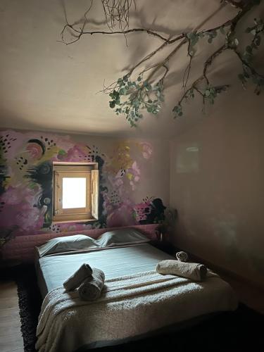 een slaapkamer met een bed met een bloemrijke muur bij Ca la Traviesa - Refugio del Arte - Pet Lovers - Adults Only - Montsant in Bellaguarda