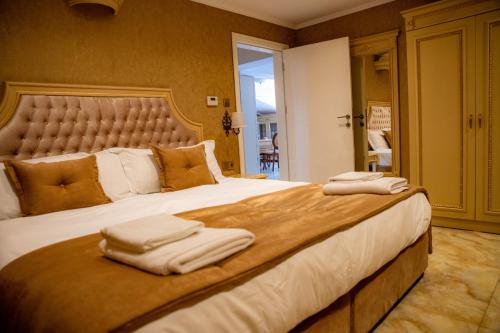 een slaapkamer met een groot bed en handdoeken bij Luxury Apartment Rich 2 in Velingrad