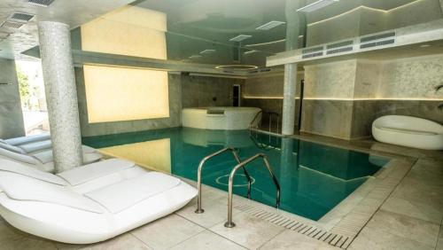 a bathroom with a swimming pool and a toilet at Luxury Apartment Rich 2 in Velingrad