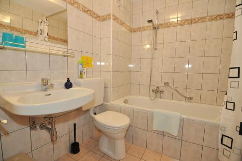 e bagno con servizi igienici, lavandino e vasca. di Pension & Apartments Weissbriach a Weissbriach