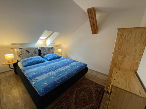 um quarto com uma cama com lençóis azuis e almofadas azuis em Apartmány U sv. Anny em Kadaň
