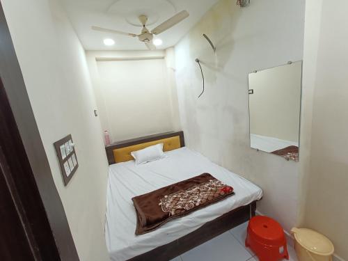 a small room with a bed and a mirror at Hotel shipra suites in Ujjain