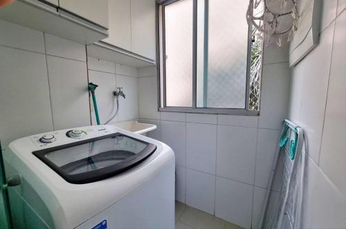 Condomínio Olhos D'agua في مويا: وجود غسالة في الحمام مع وجود نافذة