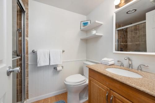 a bathroom with a toilet and a sink and a mirror at Luxury Oceanfront Condo/Indoor pool/Massage chair in Ocean City