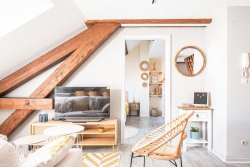 d'un salon avec des murs blancs et des poutres en bois. dans l'établissement Les Coulisses - Duplex au centre - Parking privé, à Colmar