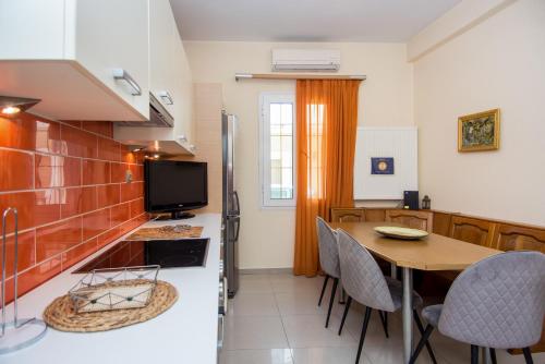a kitchen and dining room with a table and a refrigerator at Sofia's Delightful Apartment in Argostoli