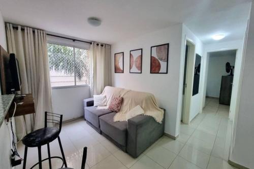 a living room with a couch and a window at Condomínio Olhos D'agua in Mauá
