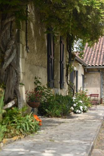 un bâtiment avec des fleurs devant un bâtiment dans l'établissement Un jardin et trois maisons, à Brux