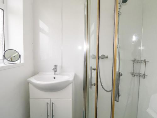 a bathroom with a sink and a shower at 28 Wordsworth Avenue in Wigan