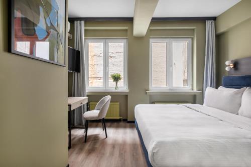 um quarto de hotel com uma cama, uma secretária e uma janela em numa I Scoop Rooms & Apartments em Bruxelas