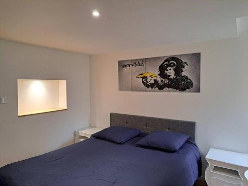 - une chambre avec un lit et une photo sur le mur dans l'établissement Camden - Extérieur et parking, à Reims