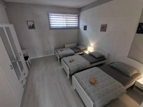 a room with three beds and a window at Apartman Marija in Livno