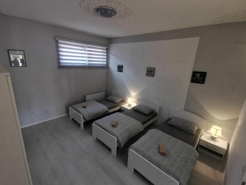 a bedroom with two beds and a window with a window at Apartman Marija in Livno