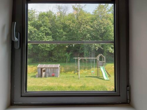 a window with a view of a playground at La Clé du Circuit Spa-Francorchamps in Stavelot