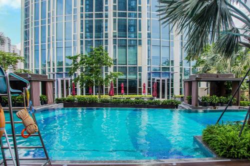 duży basen przed wysokim budynkiem w obiekcie Hyatt Regency Shenzhen Yantian w mieście Shenzhen