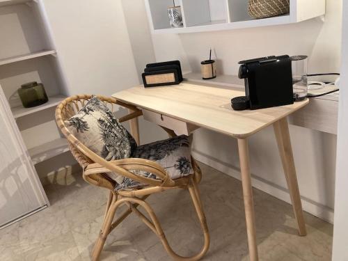 a wicker chair sitting at a table in a room at Studio cosy Cours Mirabeau au cœur d'Aix-en-Provence in Aix-en-Provence