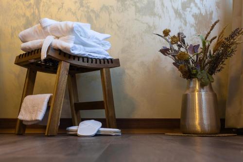 a wooden stool with a towel on it next to a vase at Grand Lakes Rooms in Plitvička Jezera