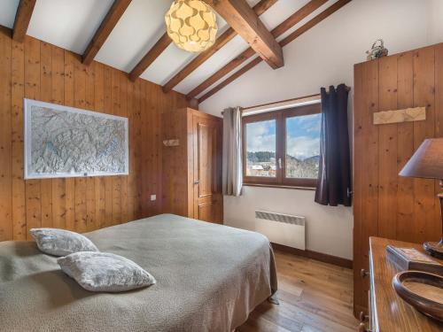 a bedroom with a bed in a room with wooden walls at Confortable 3 pièces avec animaux admis à Megève Jaillet - FR-1-453-38 in Megève