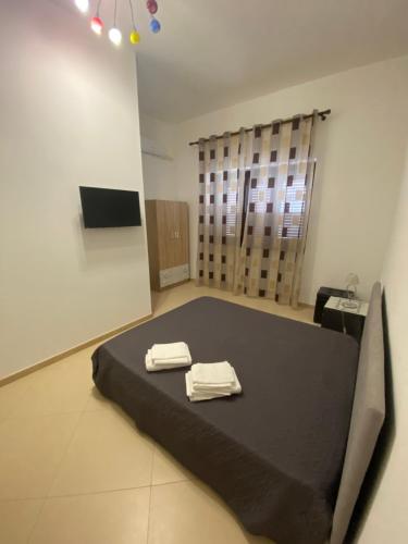 Una habitación con una cama con dos toallas. en Sabea Guest House, en Melissano