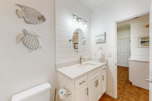 a white bathroom with a sink and a mirror at Dauphin Island Beach Club 210B in Dauphin Island