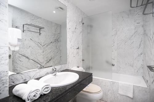 a bathroom with a sink and a toilet and a mirror at VTZ The Orus Factory Hotel - Parking Muy Económico in Zaragoza