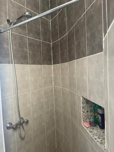 a shower in a bathroom with a tile wall at cosy Furnished appartment in Ez Zahra