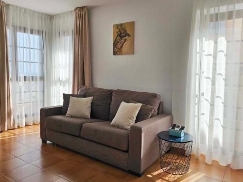 sala de estar con sofá y mesa en Apartamentos La Cebada, en Morro del Jable