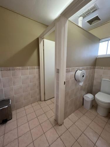 a bathroom with a toilet and a window at Adalong Student Guest House in Brisbane